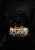 Elegant 925 silver handbag with semi precious gemstones held by a gloved hand against a dark background